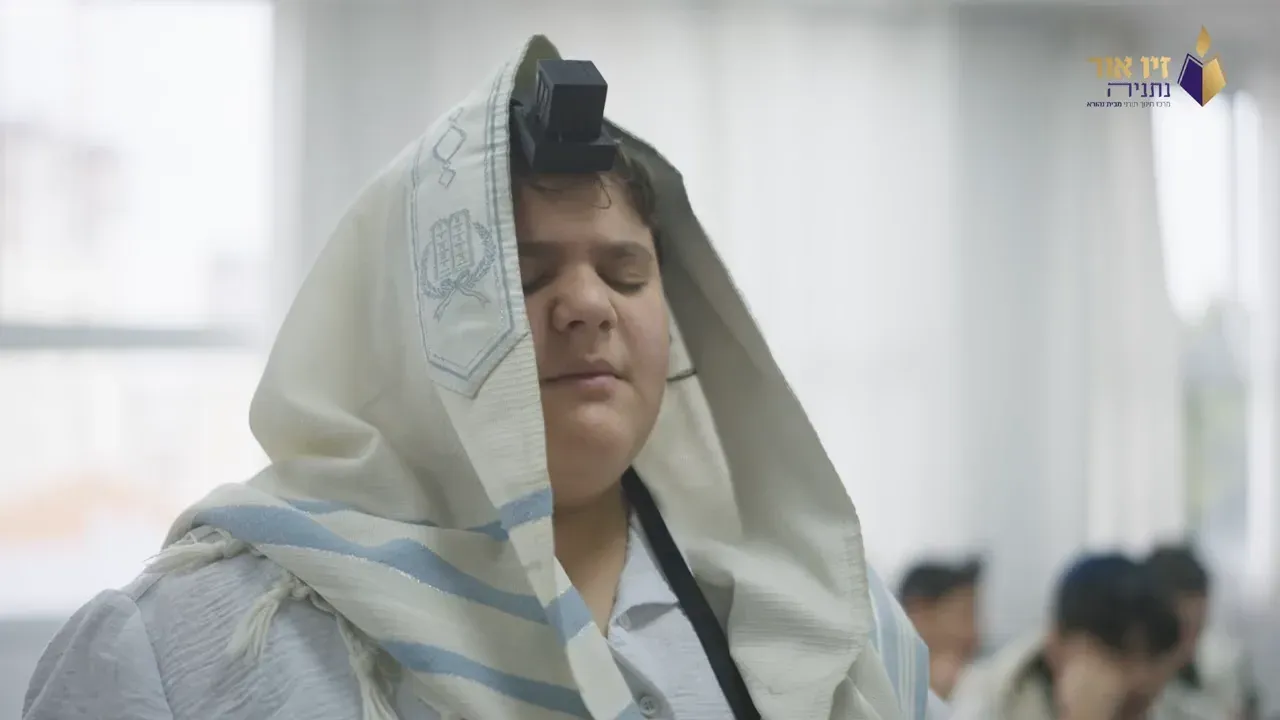 תלמיד עטוף בטלית בתפילת שחרית